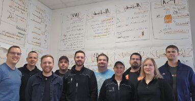 Die Referentinnen und Referenten der Aus- und Fortbildungsabteilung stehen gemeinsam vor den Lerninhalten, die an der Wand hängen.